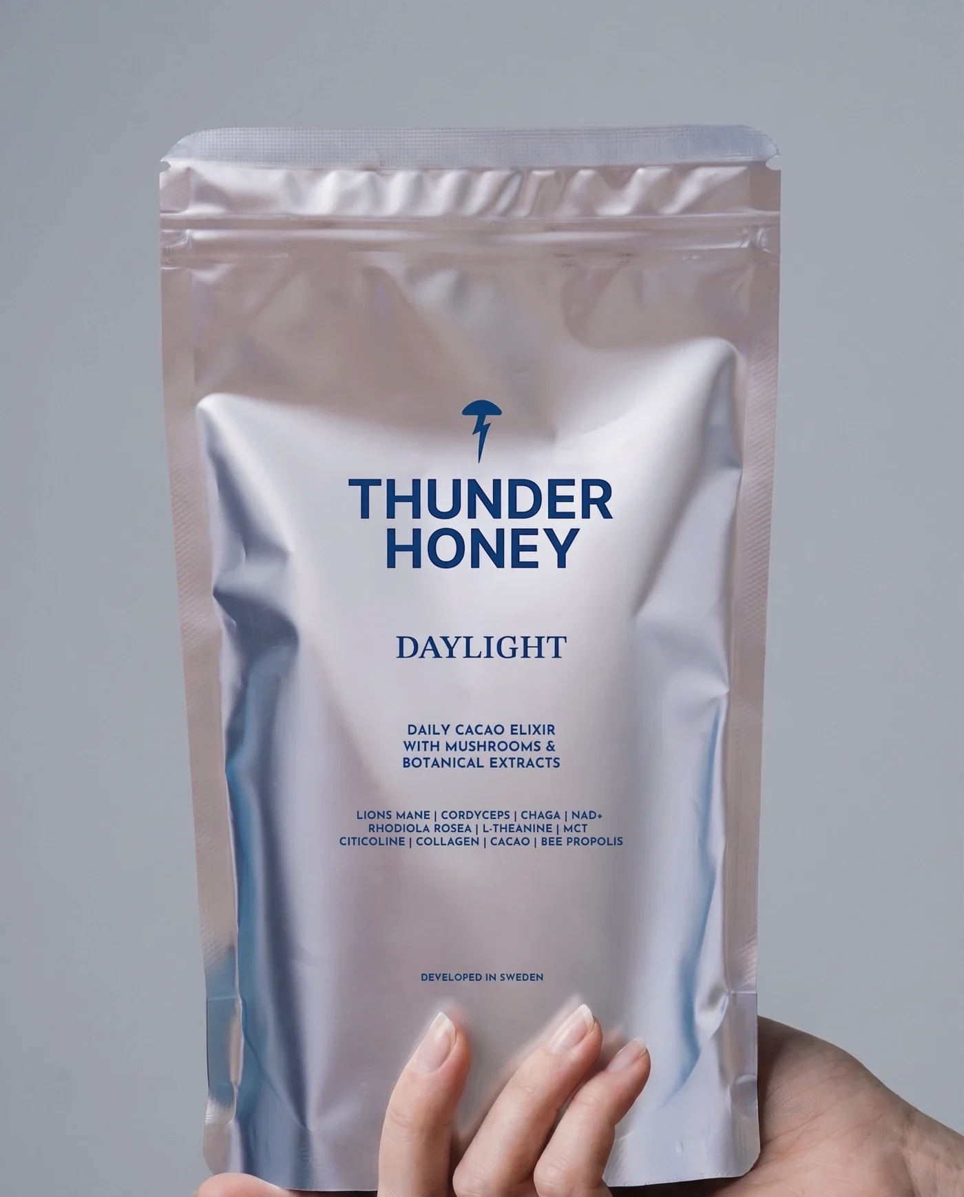 Hand holding the Thunder Honey Daylight pouch