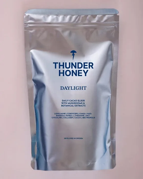 The silver Thunder Honey Daylight pouch standing against a soft pink background