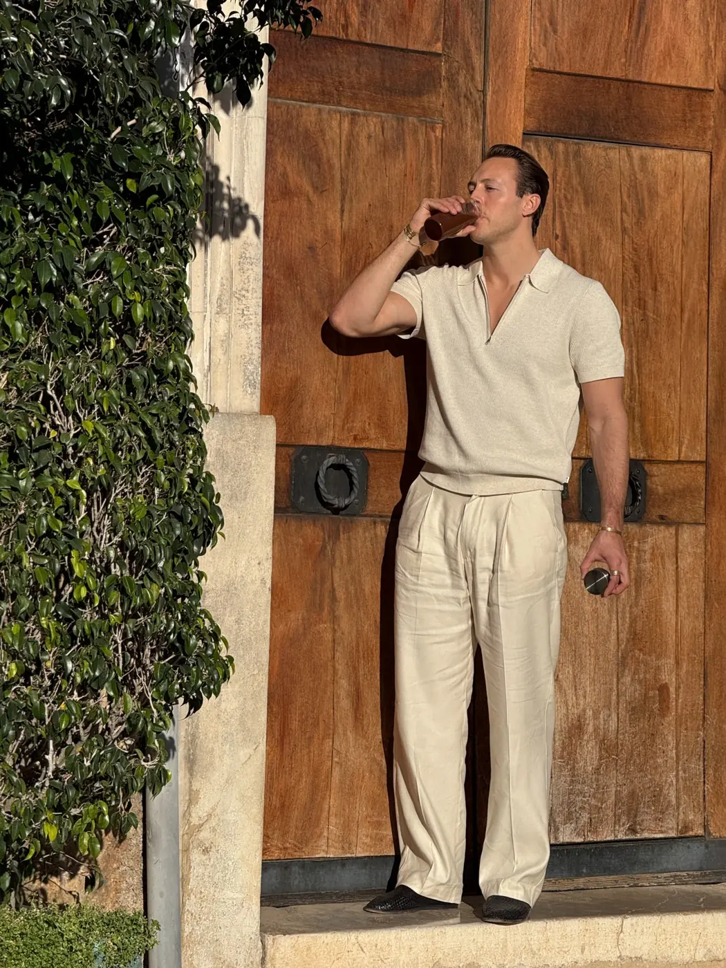Joakim Bjarke, co-founder of Thunder Honey, drinking from a glass in an old wooden doorway